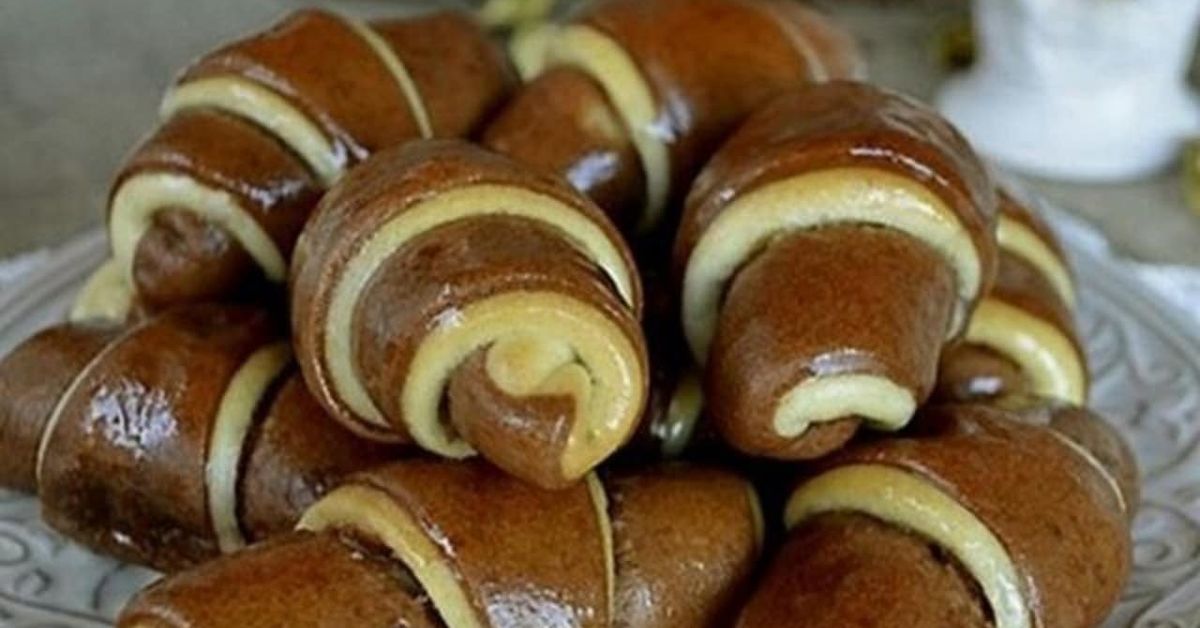Рецепта за черно-бели мини кифлички, които изчезват за минути Апетитни двуцветни кроасани с кафяви и светли ивици на декоративна чиния.