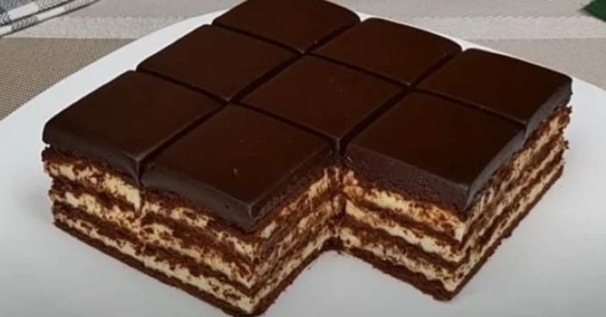 Без печене: лесна и вкусна торта с шоколад и извара Многопластова шоколадова торта с крем и тъмна глазура, нарязана на парчета.