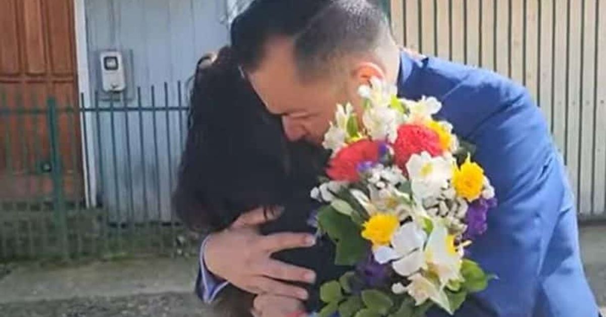 Мъж, който бе отвлечен след раждането се събра с майка си след 42 години, на нея ѝ казали, че бебето е починало Мъж в син костюм прегръща жена с букет цветя.