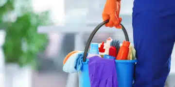 holding cleaning products and tools on bucket, close up