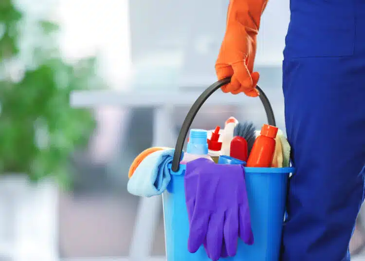 holding cleaning products and tools on bucket, close up