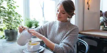 Happy woman drinking tea in cafe