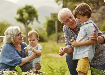 Grandparents talking to children. Family having leisure time in yard. They are wearing casuals.