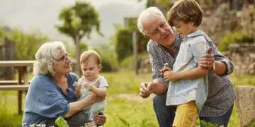Grandparents talking to children. Family having leisure time in yard. They are wearing casuals.