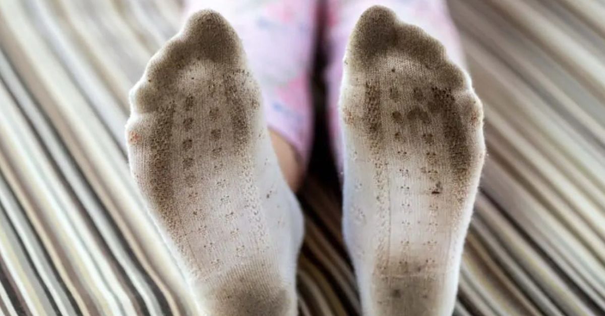 Белите чорапи ще бъдат като нови, просто ги сложете в микровърновата Мръсни бели чорапи на детски крака, стъпили на райета под.