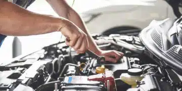 Picture showing muscular car service worker repairing vehicle.