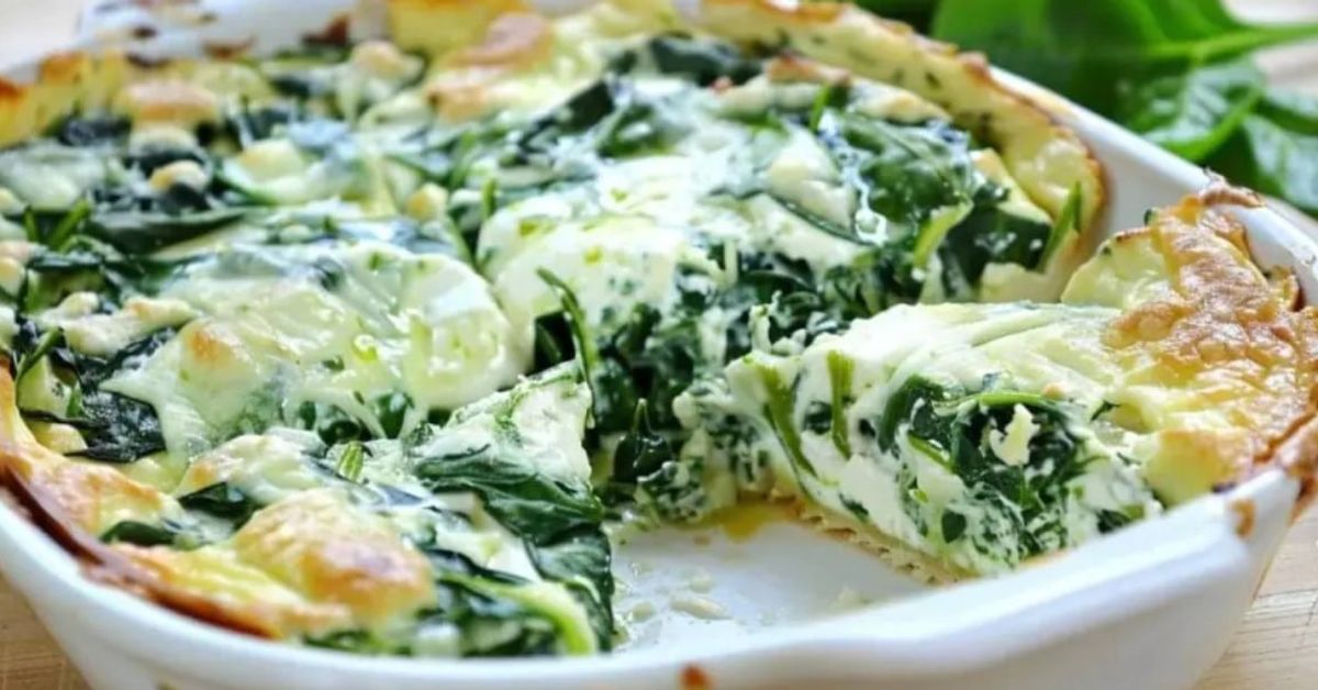 Вкусна запеканка със спанак и моцарела (Рецепта) Спаначена запеканка със сирене в бяла тава, с отрязано парче.
