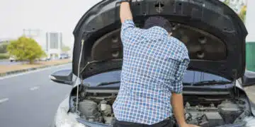 mechanic wearing gloves open car hood checking car engine oil on the road after car breakdown problem.Young man maintenance, fixing trouble car accident repair at garage workshop.