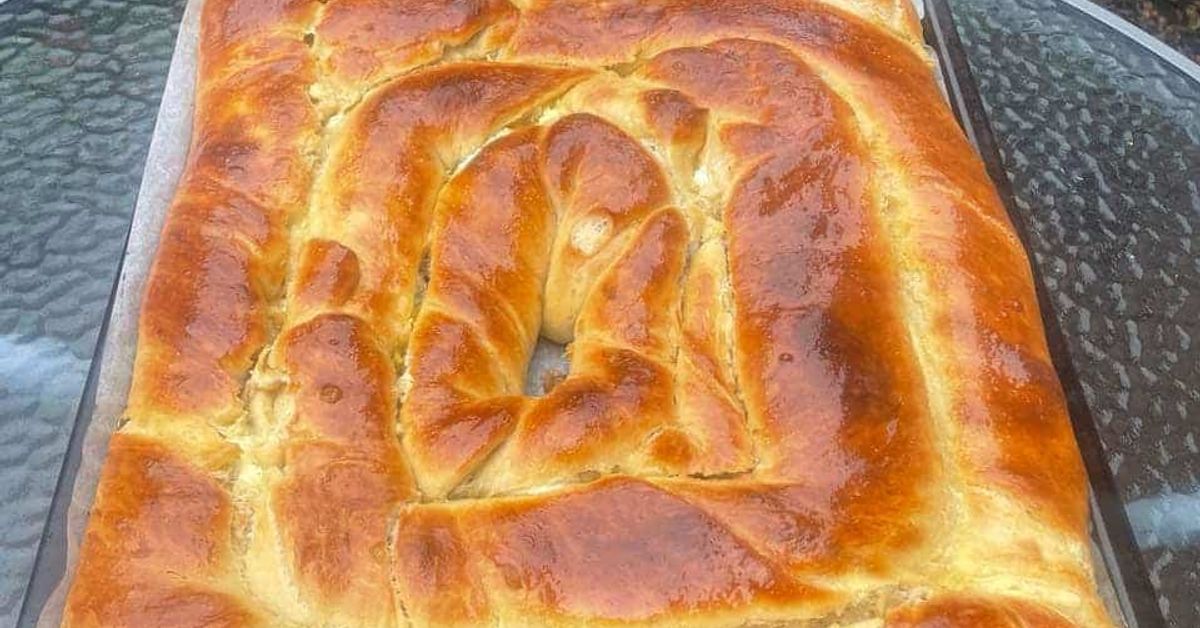Този мега бърз тутманик става от бъркано тесто - без месене, без втасване, а мек като и пухкав като памук Златиста спираловидна баница на тава върху стъклена маса на открито.