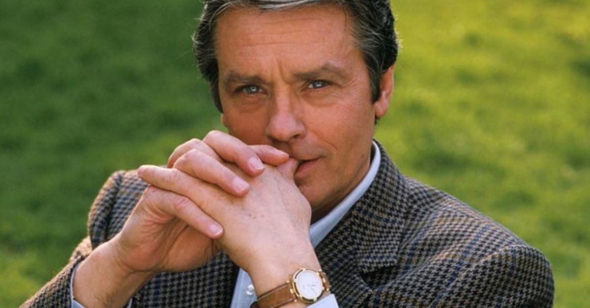Любимите жени на Ален Делон: 6 основни романа в живота на актьора Ален Делон с елегантно сако и часовник, замислен на открито.