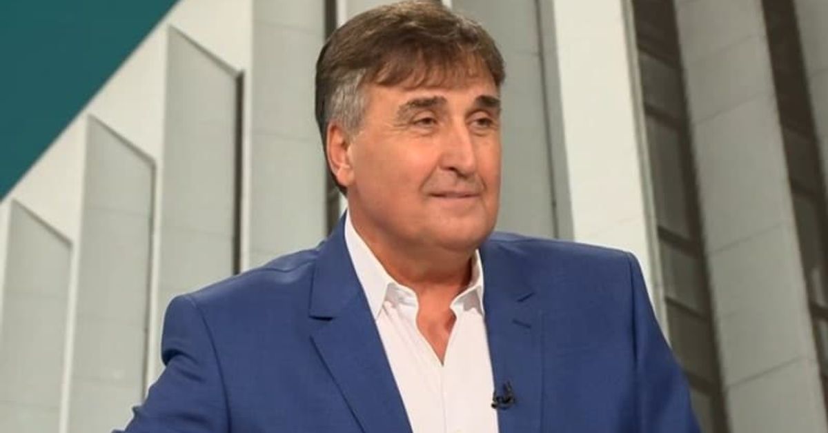 Веселин Маринов в интервю: 500 жени с жълти рокли бяха дошли на един от концертите ми Усмихнат мъж в син костюм и бяла риза пред модерен архитектурен фон