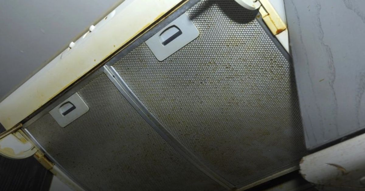 Лесно и качествено почистване на абсорбатор отвътре Мръсен кухненски аспиратор с жълти петна и омазнени метални филтри.
