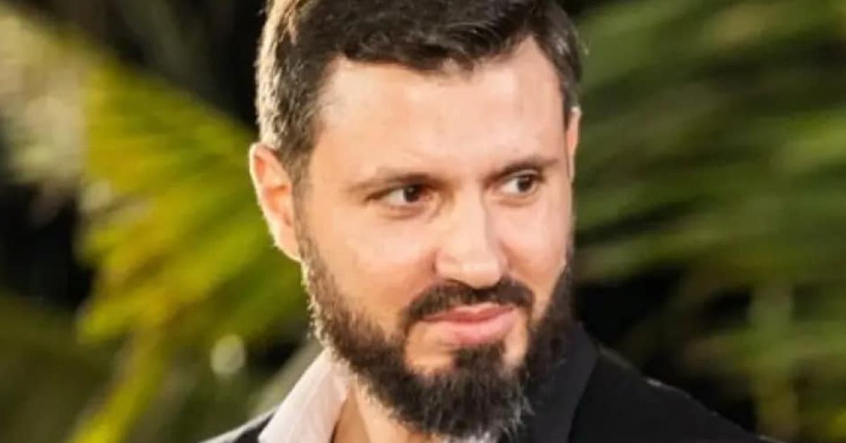 Хванаха Ергенът Мартин в крачка (Снимки) Мъж с брада и тъмен костюм, усмихнат на официално събитие на открито.