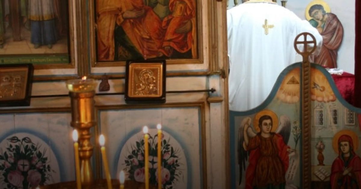 Утре 8 април е църковен празник - традиции и обичаи, които трябва да бъдат спазени! Свещеник в православна църква пред иконостас, икони и запалени свещи.