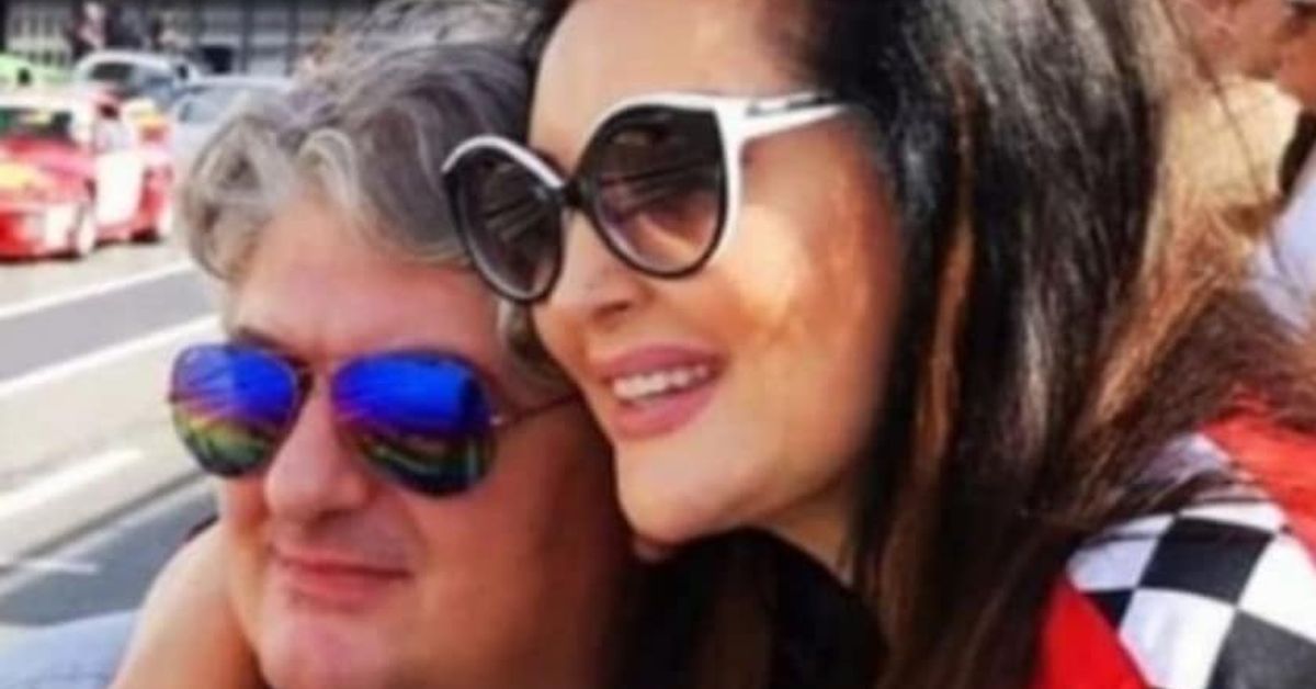 Вече официално: Легендараната певица Драгана Миркович се разведе с Тони Биелич Усмихната жена и мъж със слънчеви очила се прегръщат на фона на състезателни коли.