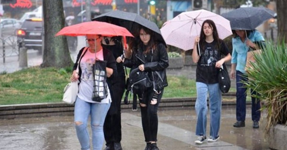 Времето у нас: очакват се бури и валежи, на места дори има риск от наводнения заради 100 литра на кв метър Хора с чадъри вървят по мокра градска улица в дъждовен ден.