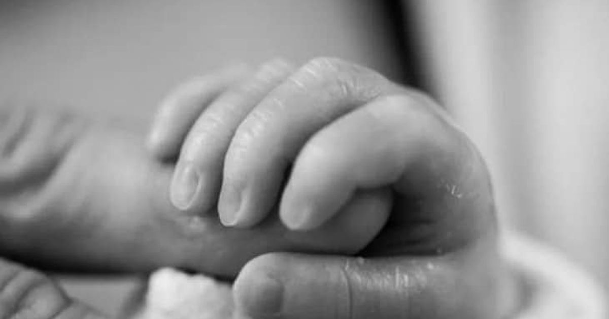 Когато в семейството се роди дете след загуба на член от семейството - какво значи това Едър план на мъничка ръчичка на новородено бебе, стискаща пръст на родител.