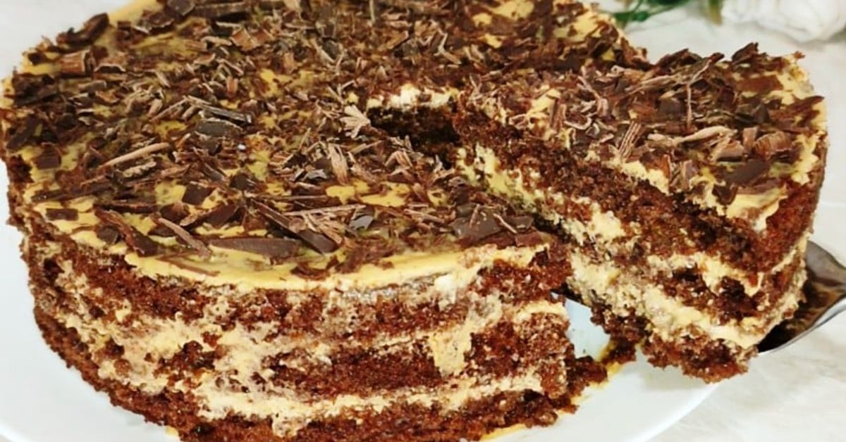 Взимам кефир и 2 яйца. Най-вкусната и лесна за приготвяне шоколадова торта Шоколадова торта с крем и настърган шоколад, от която е отрязано парче.