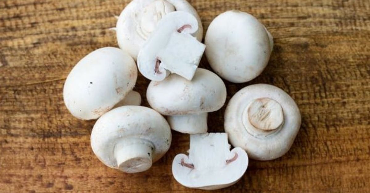 Да белиш гъби или не? Основното правило на гъбаря за запазване на вкуса на ястието Пресни бели печурки, цели и нарязани, върху дървена дъска.