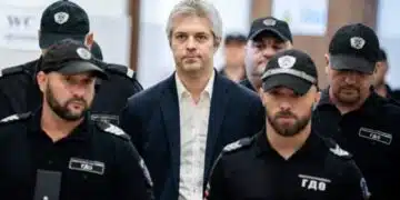 Мъж, придружен от охрана.