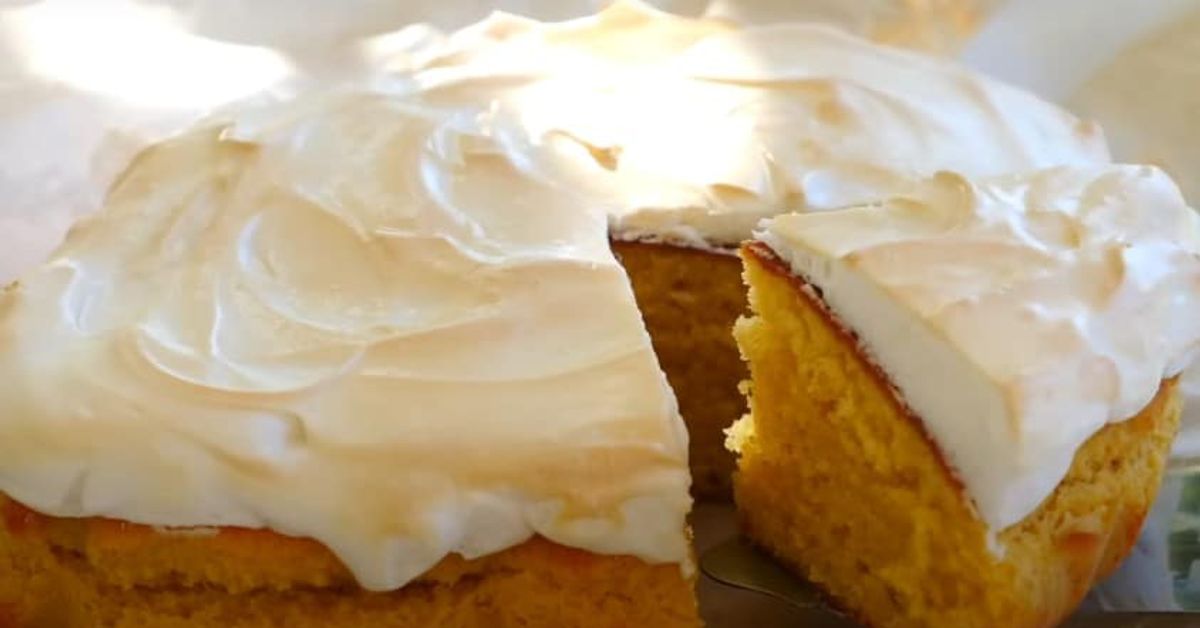 Вкусен ванилов пай с протеинов крем. Печен във фурна Торта с жълт блат и бял меренг крем, сервирана с отрязано парче.