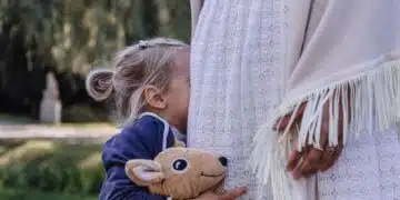 Дете с играчка до корема