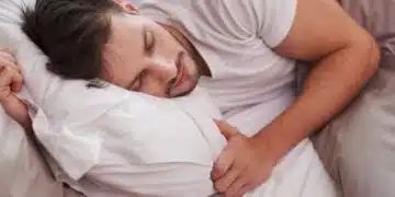 Млад мъж спи на възглавница.