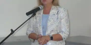 Жена говори на микрофон.
