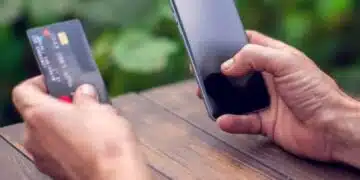 Телефон и дебитна карта в ръка