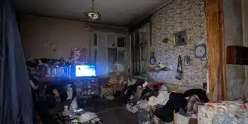 Разхвърлян апартамент с телевизор.