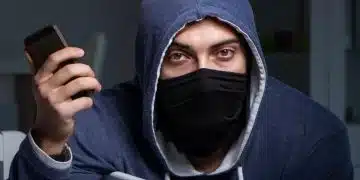 Мъж с телефон в тъмна стая.