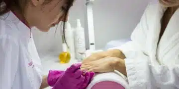 Жена получава маникюр в салон.
