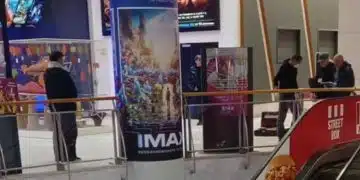Хора в мол с киноафиши.
