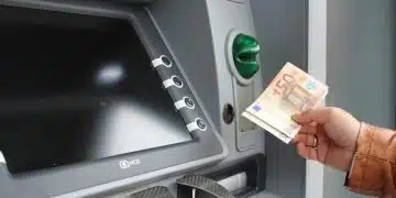 Човек взима пари от банкомат.