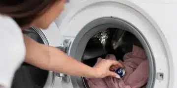 Жена слага прах за пране.
