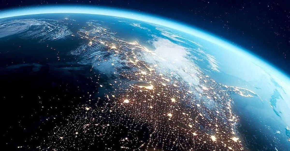 Смразяващо предсказание за следващата 2026 година дойде от НАСА Земята от космоса през нощта, с градски светлини и синя атмосфера.