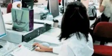 Жена работи на компютър в офис.