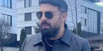 Мъж в черно яке на улицата.