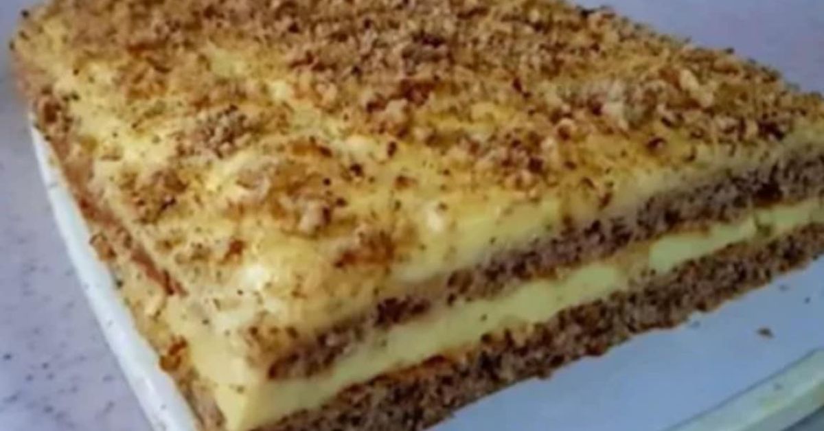 Неустоимата орехова торта на баба – аромат и спомени в едно Апетитна торта с няколко слоя кафяв блат, жълт крем и поръсена с ядки.