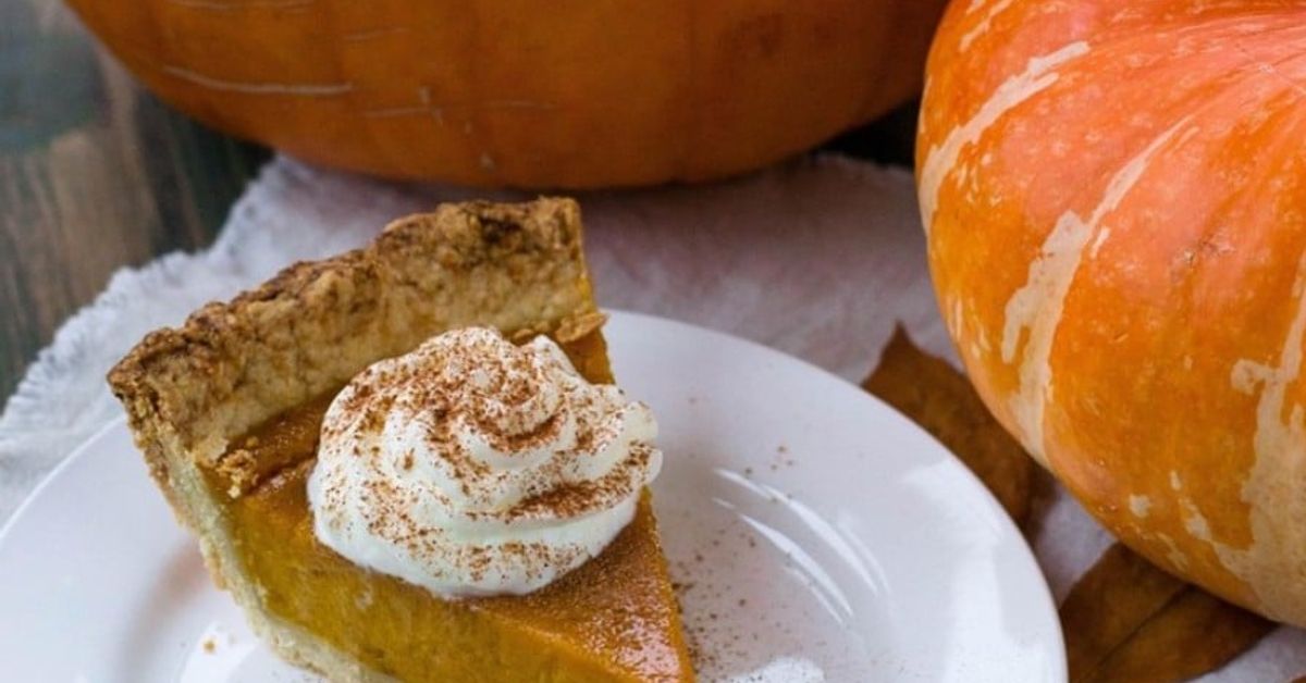 Лесна и бърза печена тиква на фурна Вкусна порция тиквен пай със сметана и канела на фона на есенни тикви.