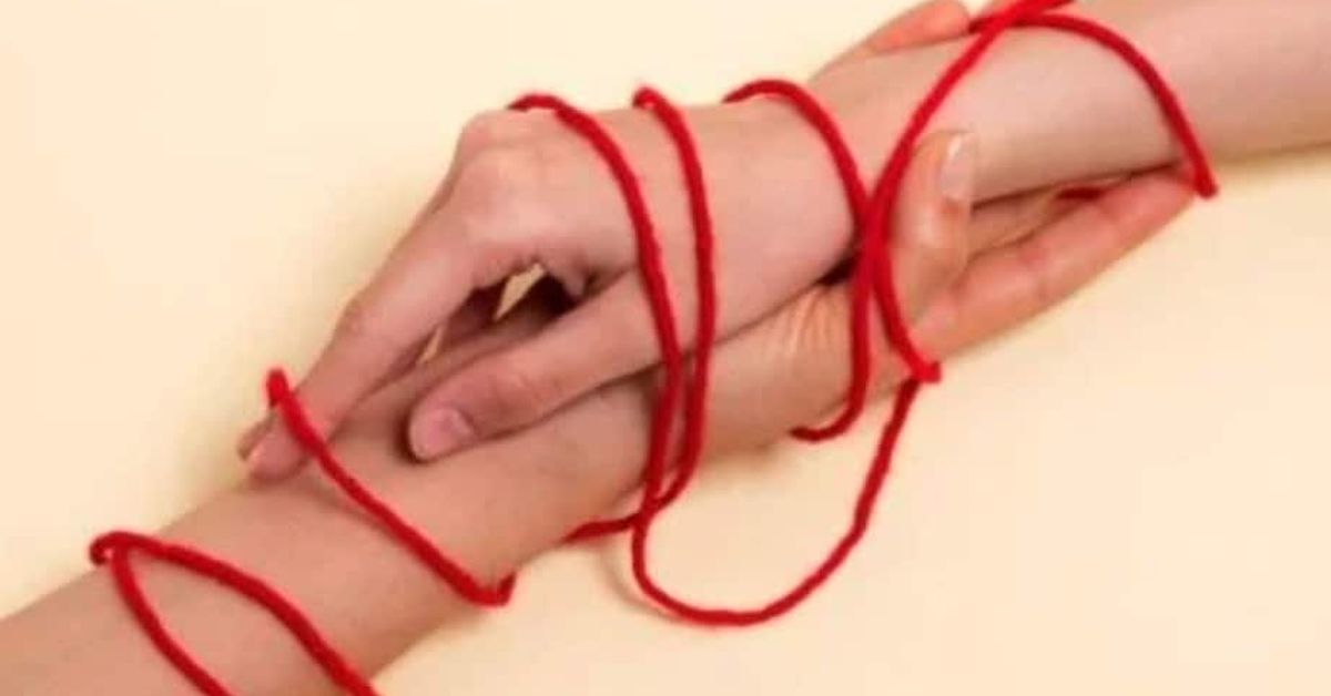 Синдром на Отело: Когато ревността надхвърля границите Две ръце, свързани с червен конец, символизиращи силна връзка и съдба.