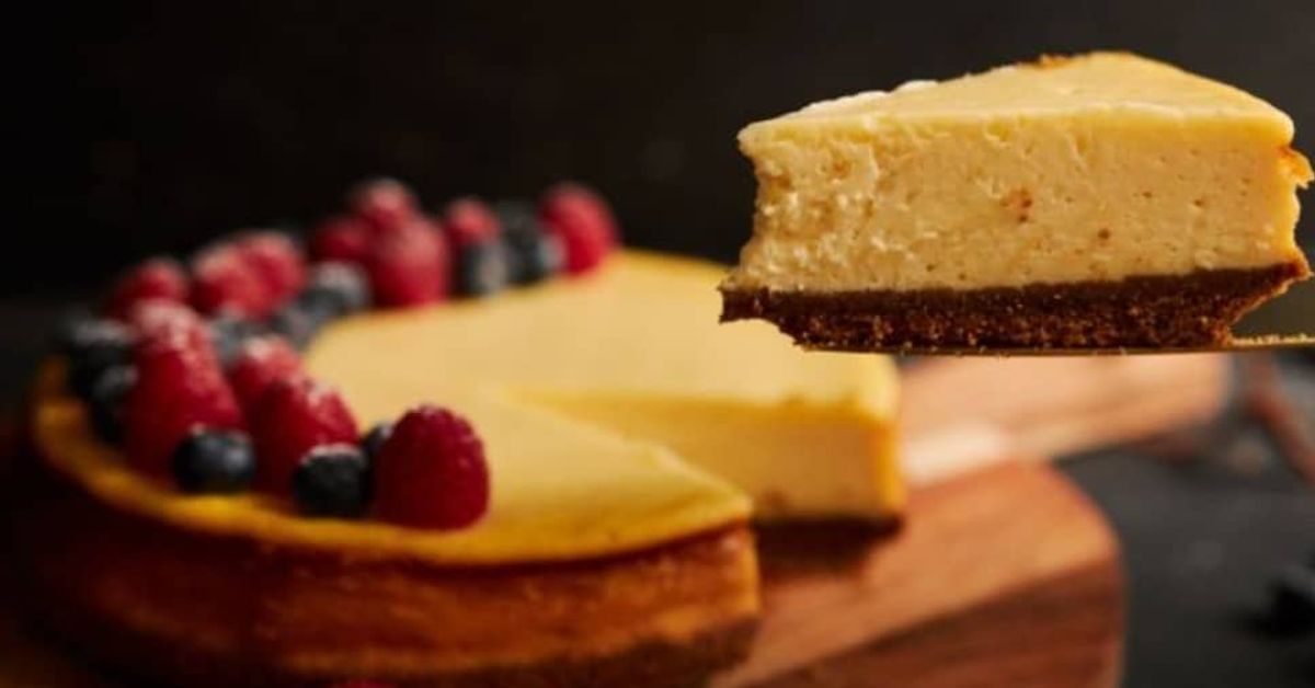 Рецепта за чийзкейк с тиква: Вкусът на този десерт ще изуми всички Чийзкейк с горски плодове, едно парче се вдига, показвайки кремообразната плънка.