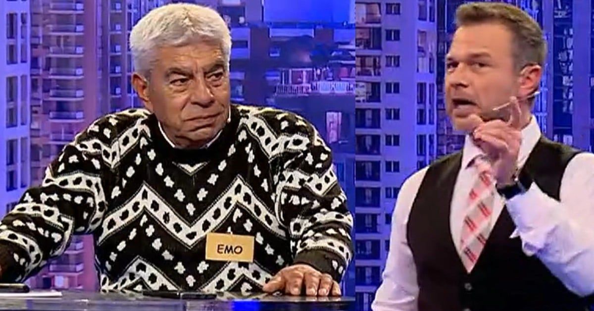 Облог за 3 000 лева изкуши Емин в „Сделка или не“ Мъж с пуловер и табелка EMO до водещ, който говори в телевизионно предаване.