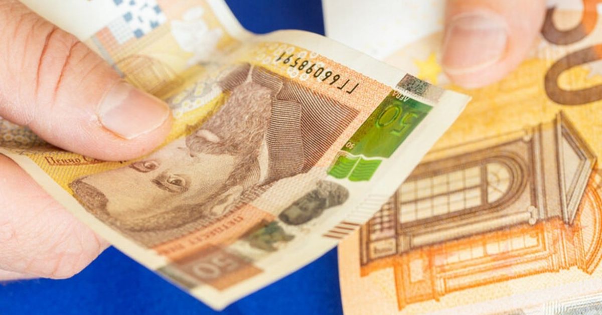 Как ще се отрази краят на българския лев и какво трябва да знаят хората Ръце държат банкноти от 50 лева и 50 евро на син фон.