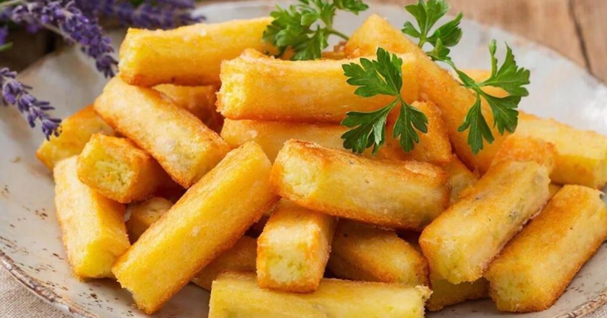 Тези луди пръчици от извара и картофи са идеалното предястие за трапезата Златисти пържени пръчици от юка, гарнирани със свеж магданоз на чиния.