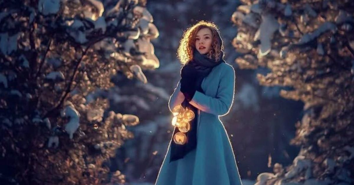 Ключове към бъдещето: три зодии, за които сезонът на Водолея бележи начало на нов живот Млада жена в синьо палто държи светещи лампички в заснежена зимна гора.