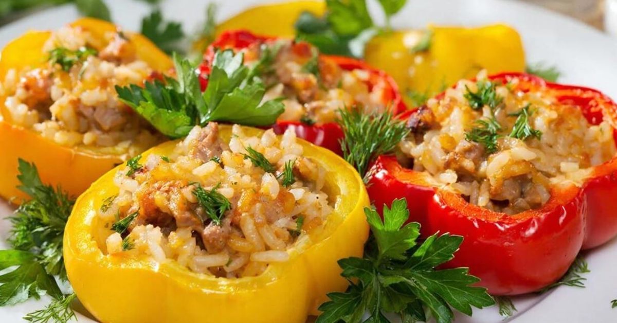 Семейството ми иска още от тези пълнени чушки: вкусни лакомства на котлон Пълнени жълти и червени чушки с ориз и кайма, гарнирани със свежи подправки.