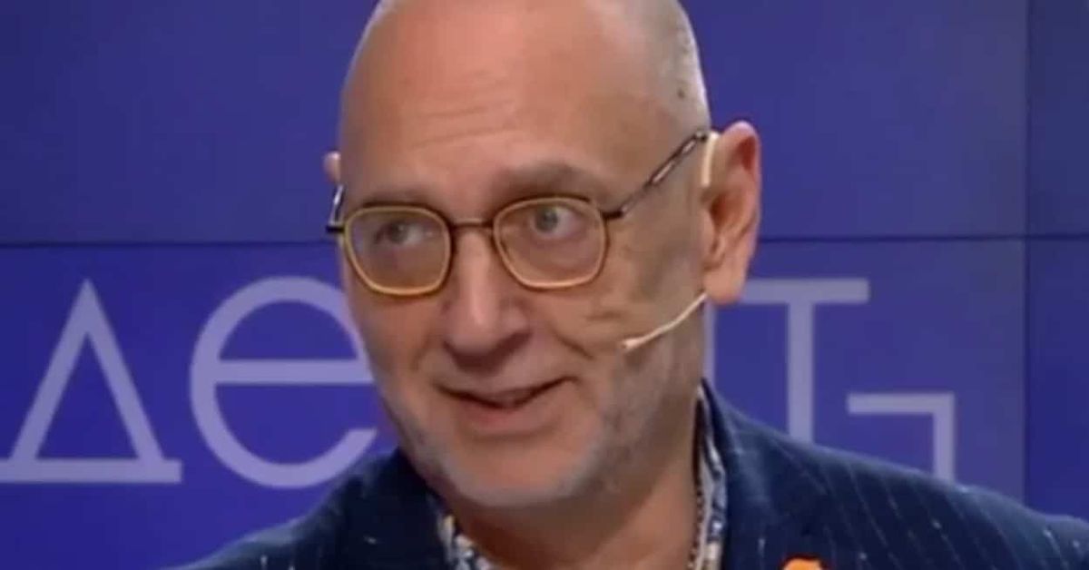 Нашия свят напусна Любен Дилов - син, ето и последните му думи Усмихнат плешив мъж с очила и микрофон пред син фон с кирилски букви.
