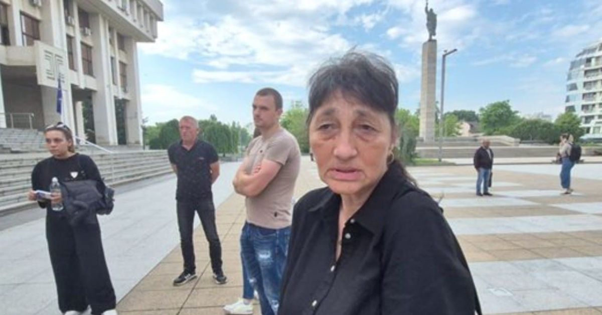 След трагедията с АТВ-то: майката на Христина с тежки думи към извършителя Възрастна жена и хора на градски площад пред голяма сграда и паметник.